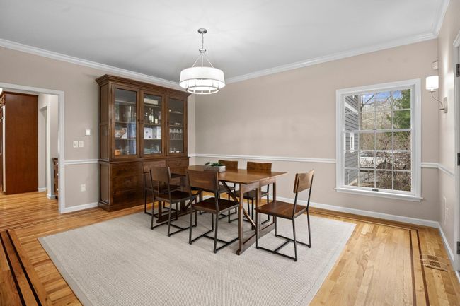 The elegant formal dining room features hardwood floors, crown molding, and abundant natural light for refined entertaining. | Image 18