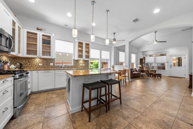 Kitchen with a center island, appliances with stainless steel finishes, a healthy amount of sunlight, and a ceiling fan | Image 9