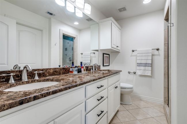 Bathroom featuring double vanity, a shower stall, tile patterned flooring, and recessed lighting | Image 16