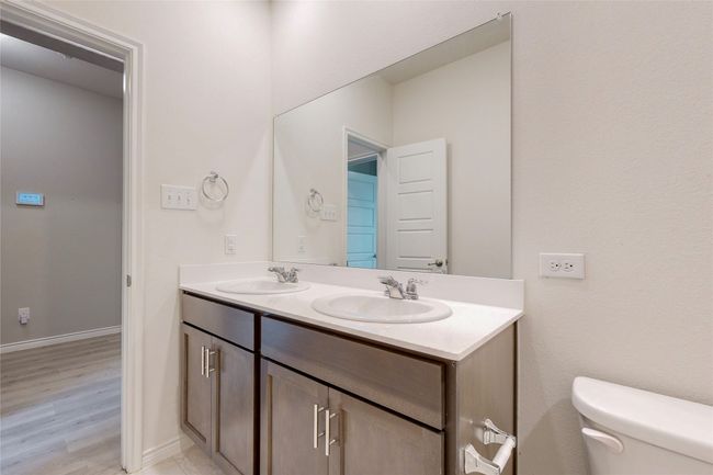 Bathroom with double vanity, wood finished floors, toilet, and a sink | Image 20