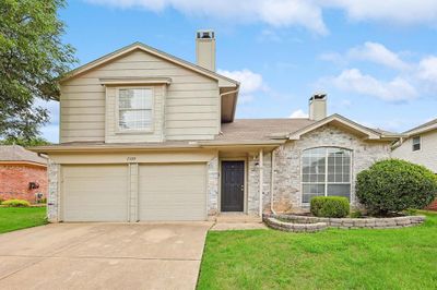 View of front facade featuring a front yard and a garage | Image 1