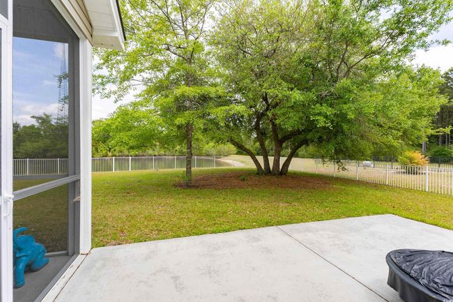 View of yard featuring a fenced backyard, a water view, and a patio area | Image 27