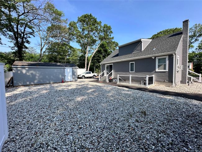 View of home's exterior featuring a chimney, a shingled roof, and an outbuilding | Image 7