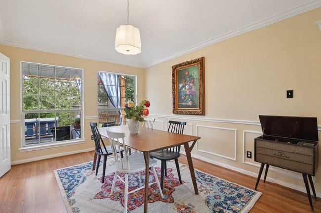 Bright dining room with wood flooring and large windows offering plenty of natural light. | Image 10
