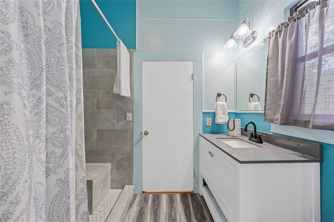 Full bath featuring vanity, wood finished floors, and a tile shower | Image 11