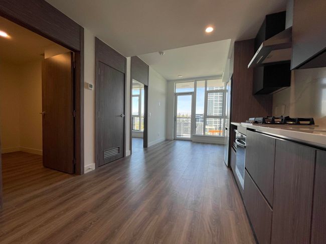 Kitchen with baseboards, wood finished floors, modern cabinets, and light countertops | Image 11