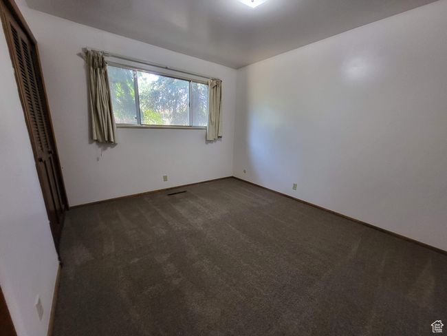 Empty room featuring dark carpet and baseboards | Image 7