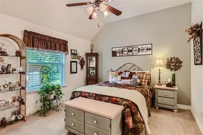 Bedroom with baseboards, lofted ceiling, light colored carpet, and a ceiling fan | Image 25