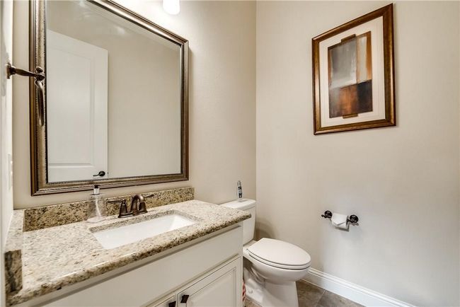 Half bath featuring toilet, vanity, tile patterned flooring, and baseboards | Image 25