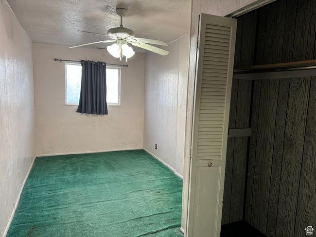 Unfurnished bedroom featuring carpet, a closet, a ceiling fan, baseboards, and a textured ceiling | Image 17