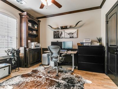 Office area with crown molding, light hardwood / wood-style floors, and ceiling fan | Image 3