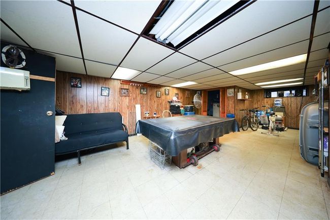 Playroom with wooden walls, a paneled ceiling, tile patterned floors, and billiards table | Image 22