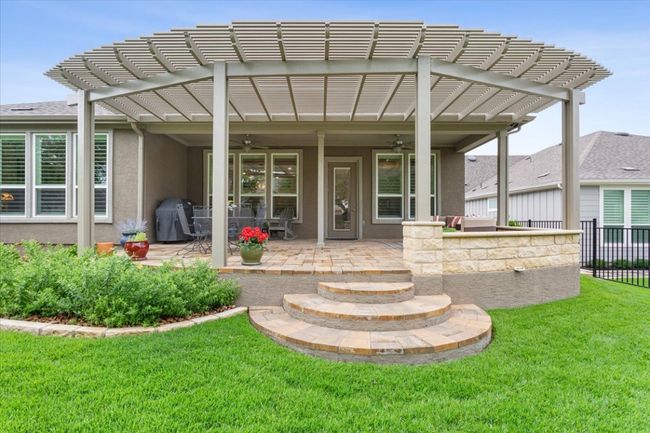 Back of house featuring two ceiling fans, a butterfly garden, and a large entertaining area. | Image 34