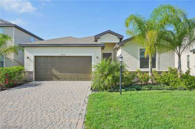 Ranch-style home with a garage and a front yard | Image 1