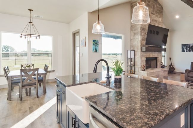 Kitchen featuring visible vents, open floor plan, a sink, light wood-style flooring, and a notable chandelier | Image 9