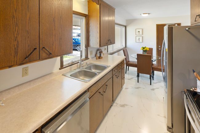 Stainless appliances in kitchen as well as new flooring. | Image 10