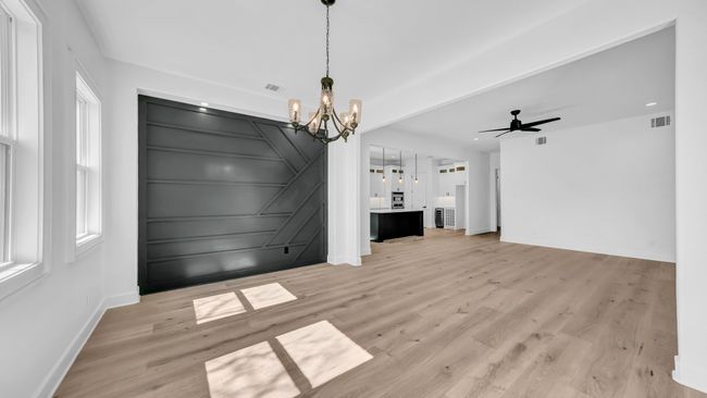 Unfurnished dining area featuring a decorative wall, light wood-style floors, and visible vents | Image 13