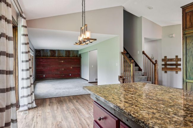 The kitchen has a granite center island with a breakfast bar | Image 5