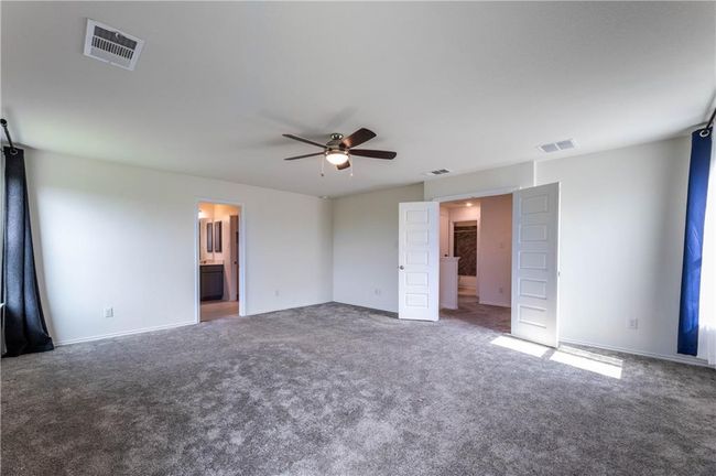 Unfurnished bedroom with carpet, connected bathroom, and ceiling fan | Image 20