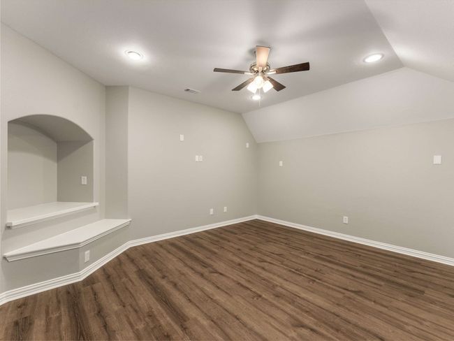 Additional living space featuring baseboards, wood finished floors, a ceiling fan, and vaulted ceiling | Image 27