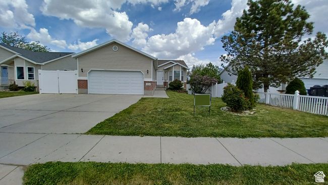 View of front of home with an attached garage, brick siding, and concrete driveway | Image 32