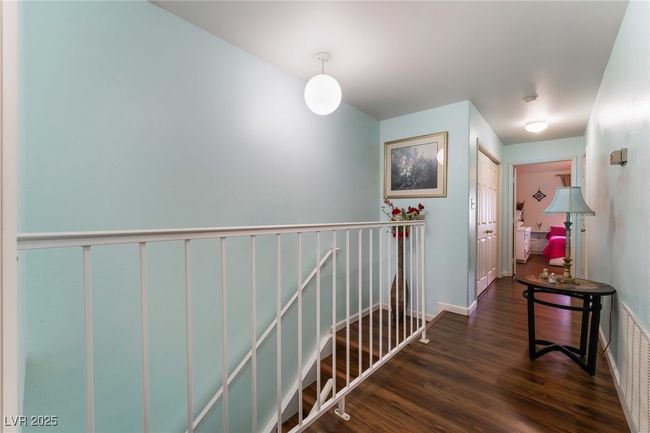 Hallway with an upstairs landing, visible vents, wood finished floors, and baseboards | Image 17