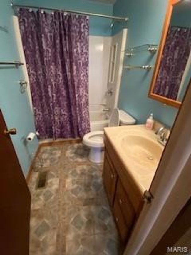 Bathroom featuring vanity, toilet, and shower / tub combo | Image 6