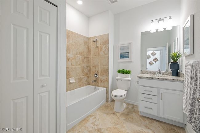 Bathroom with a closet, baseboards, washtub / shower combination, toilet, and vanity | Image 33