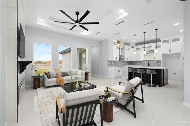 Living area featuring a raised ceiling, ceiling fan, recessed lighting, and baseboards | Image 4