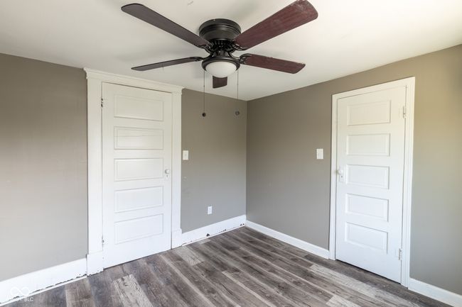 empty room with baseboards, a ceiling fan, and dark wood-style flooring | Image 30