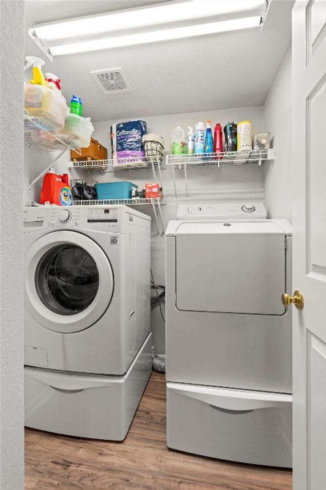 Laundry room with independent washer and dryer, visible vents, wood finished floors, and laundry area | Image 13