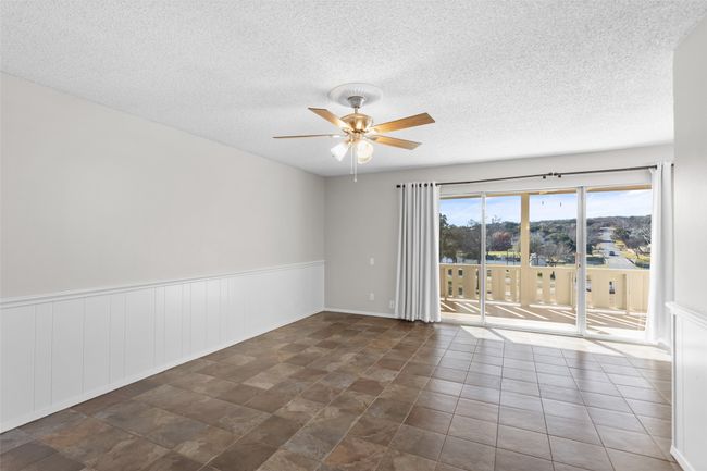 Spare room featuring a textured ceiling, ceiling fan, and wainscoting | Image 20