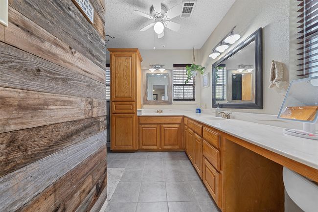 Bathroom featuring a textured ceiling, double vanity, visible vents, a ceiling fan, and tile patterned flooring | Image 18