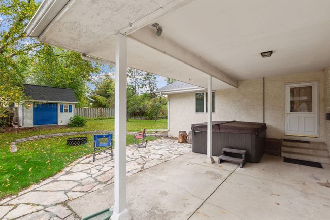 Patio with covered overhang and hot tub. | Image 31