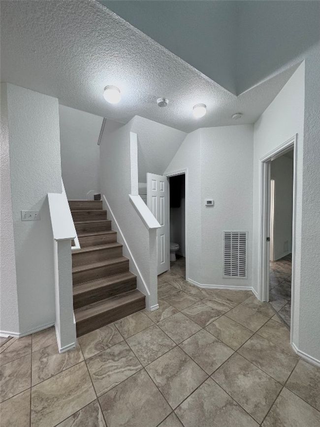 Staircase with a textured ceiling and lofted ceiling | Image 6