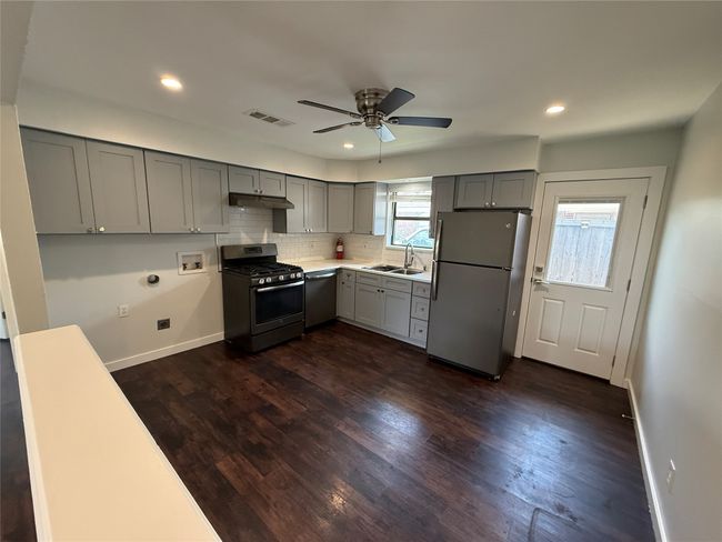 Kitchen featuring stainless steel appliances, gray cabinetry, a ceiling fan, under cabinet range hood, and recessed lighting | Image 5