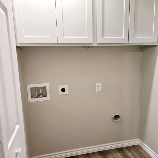 Laundry room featuring wood finished floors, hookup for a washing machine, baseboards, electric dryer hookup, and cabinet space | Image 9
