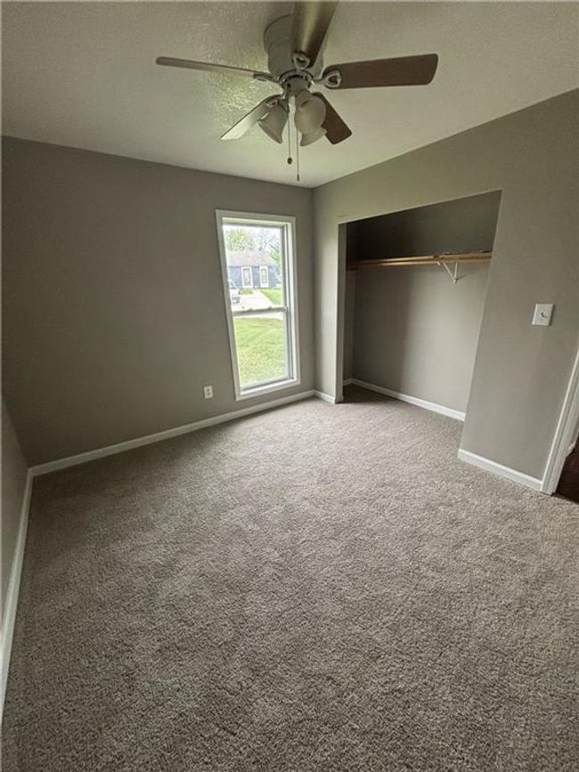 Unfurnished bedroom with a closet, carpet flooring, a ceiling fan, and baseboards | Image 17