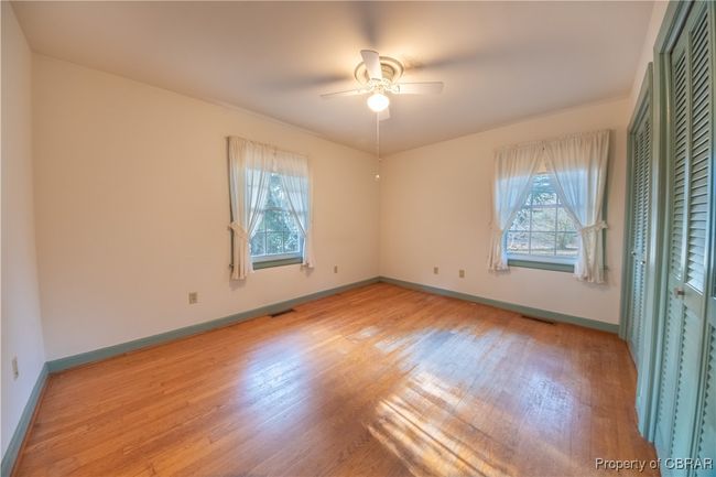 Unfurnished bedroom featuring light hardwood / wood-style flooring and ceiling fan | Image 22