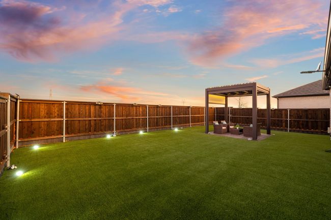 Yard at dusk with an outdoor hangout area, a pergola, and a patio | Image 25