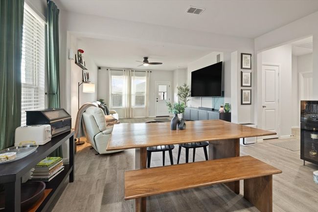 Living area featuring light wood-style floors, a ceiling fan, and baseboards | Image 16