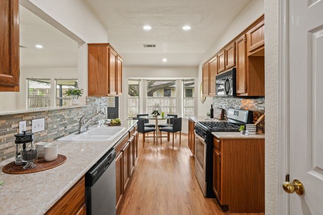 Gas range and pass-through window make cooking and entertaining easy. 9349 Bernoulli Dr., Austin, TX 78748 | Image 8