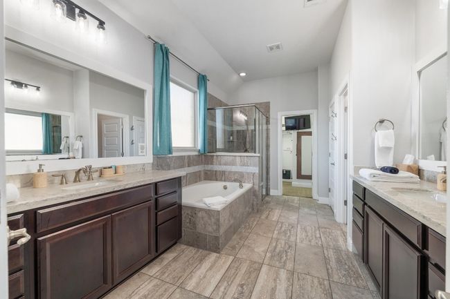 Luxuriate in this fabulous primary bathroom with separate dual vanities, soaking tub, separate shower. | Image 25