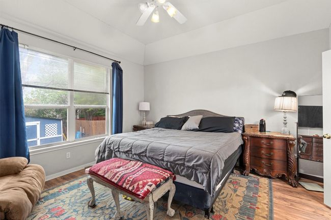 Bedroom with a ceiling fan, lofted ceiling, baseboards, and light wood finished floors | Image 10