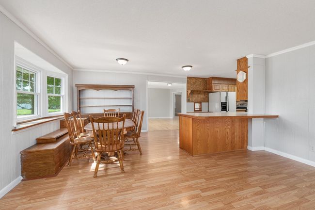 Dining area with ornamental molding and light wood-style floors | Image 10
