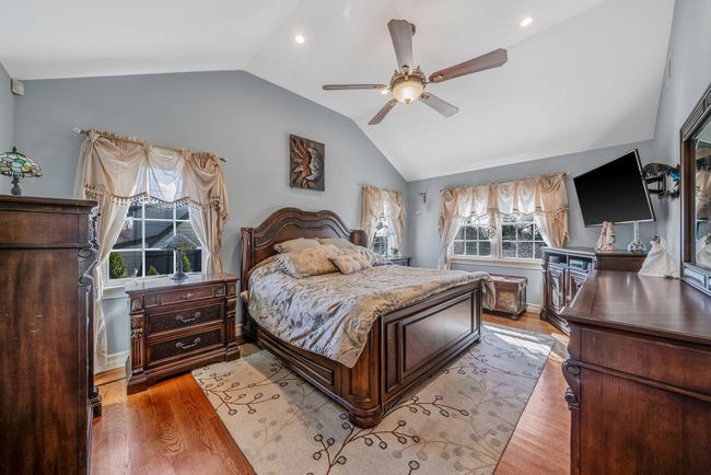 Bedroom featuring baseboards, lofted ceiling, light wood-style floors, and a ceiling fan | Image 15