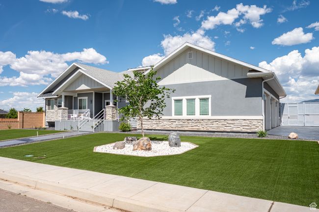 View of front of property featuring stone siding, a porch, board and batten siding, and stucco siding | Image 11