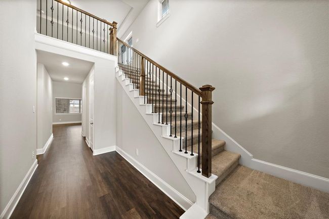 At the entryway, there is a staircase that leads to the 2nd floor featuring a catwalk over the hallway. | Image 4