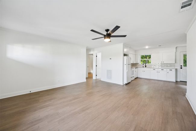 Unfurnished living room featuring a ceiling fan and light wood-style flooring | Image 5