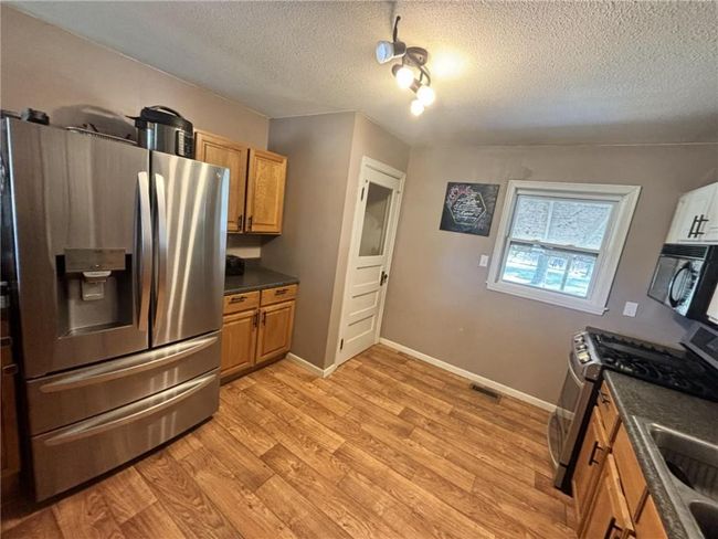 Kitchen featuring stainless steel appliances and laminate flooring | Image 11
